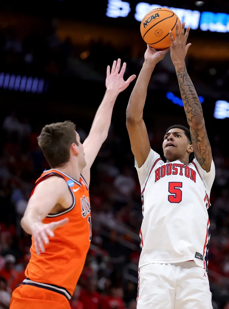A Houston Cougars player in a white jersey shoots a basketball over a Syracuse Orange player in an orange jersey.