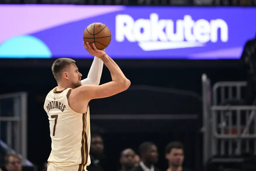 Kristaps Porzingis in a Washington Wizards jersey shoots a basketball.