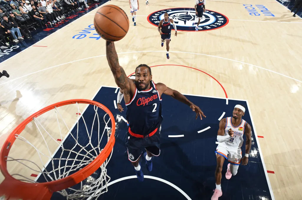 Kawhi Leonard of the Los Angeles Clippers dunking the basketball over an Oklahoma City Thunder player.