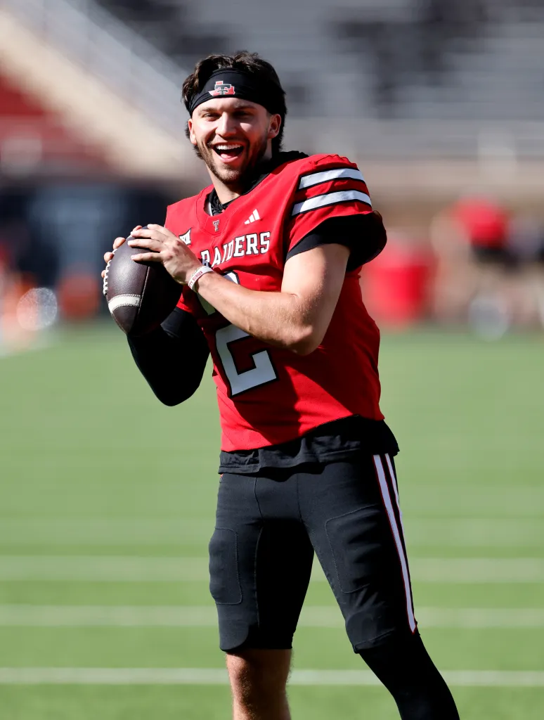 Brendan Sorsby smiling while holding a football.