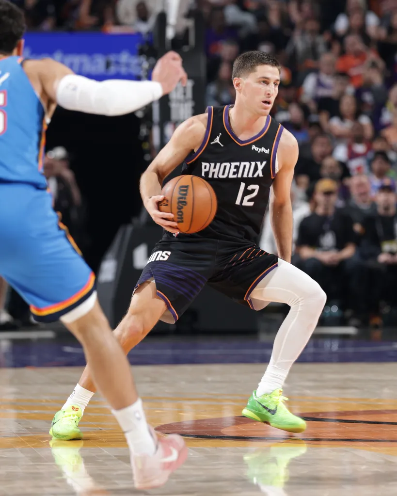 Phoenix Suns player Joe Wieskamp dribbles the ball on the court against an Oklahoma City Thunder opponent.