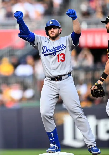 Max Muncy celebrates on base in his grey Dodgers uniform with number 13.