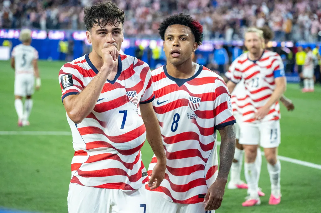USA players Weston McKennie (8) and Gio Reyna (7) walk on the field in a FIFA World Cup 2026 match against Paraguay.