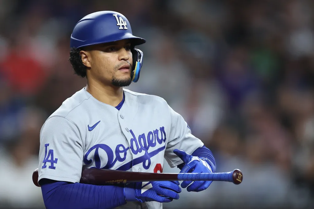Santiago Espinal holding a bat and wearing a Dodgers jersey.