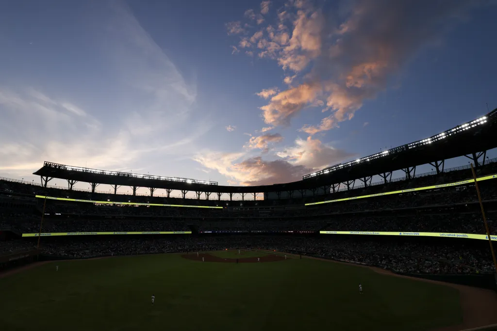 Baseball game in progress between the San Francisco Giants and Atlanta Braves with a sunset sky overhead.