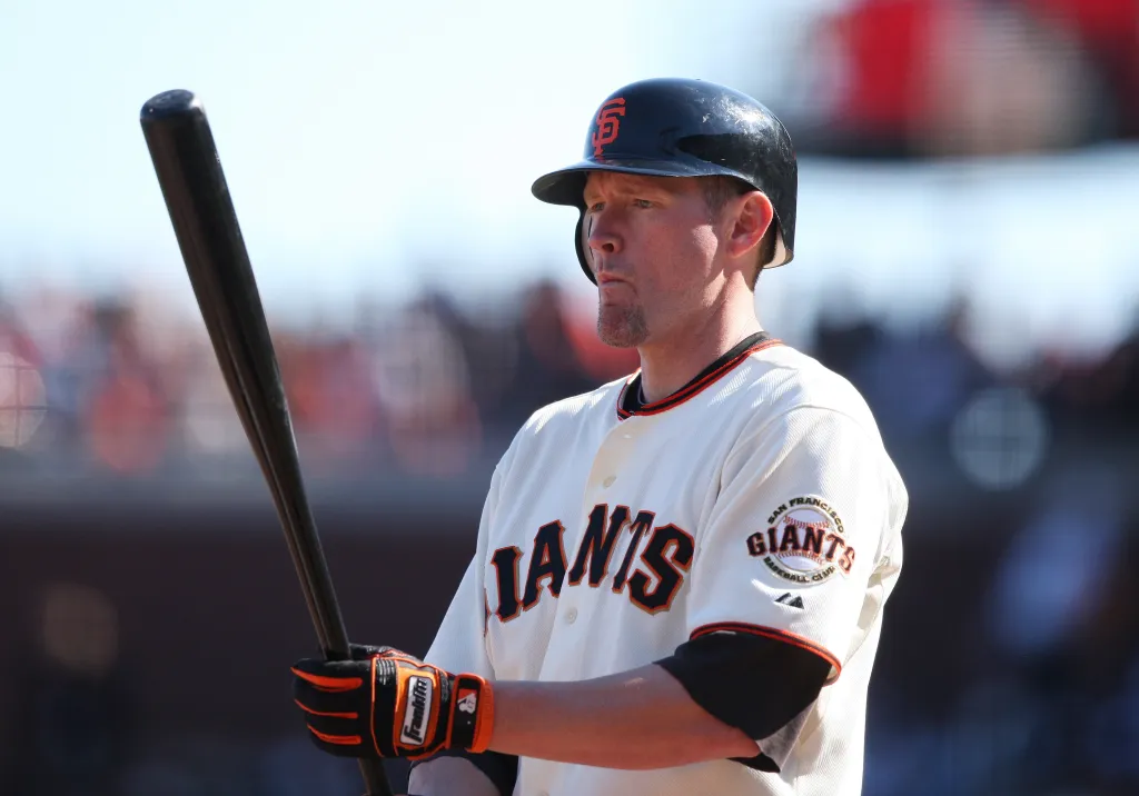 A baseball player for the San Francisco Giants holds a bat over his shoulder.