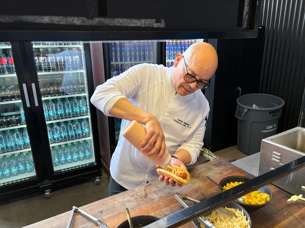 Executive sous chef Camilo Baquero prepares the fried Ripper Hot Dog with pineapple salsa, ketchup mayo, diced pineapple and potato sticks.