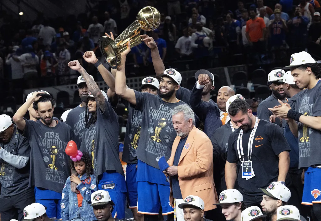 A jubilant Karl-Anthony Towns celebrates with owner James Dolan and his Knicks teammates after their 94-90 Game 5 NBA title-clinching win over the Spurs on June 13, 2026 in San Antonio. 