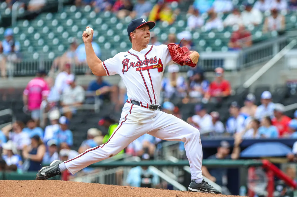 A Braves pitcher on the mound throws a baseball.