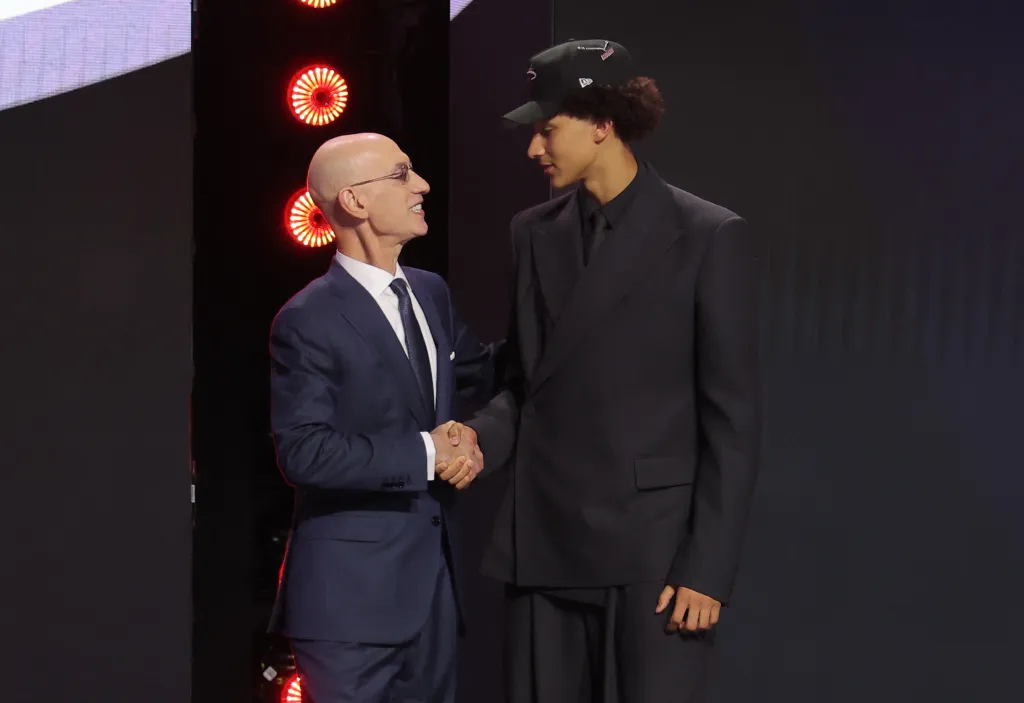 NBA Commissioner Adam Silver shakes hands with a newly drafted player.
