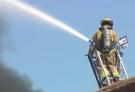 A firefighter battles a massive fire at a storage facility in Los Angeles.