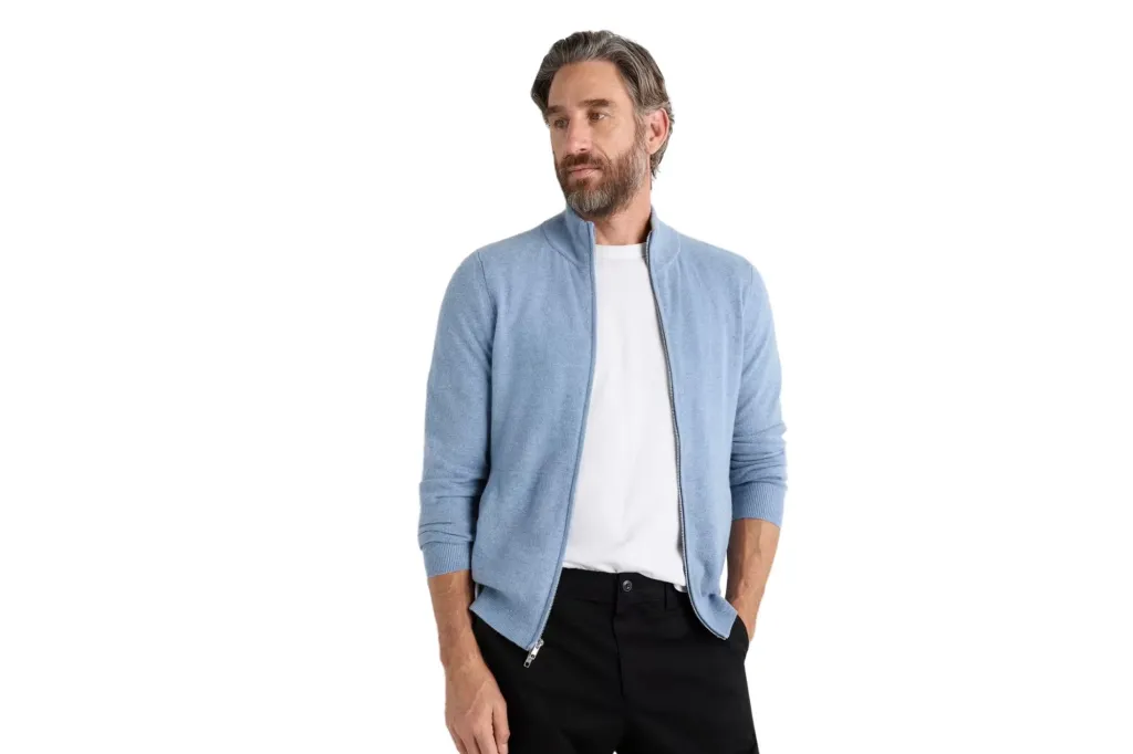 A man wearing a blue zip up sweater