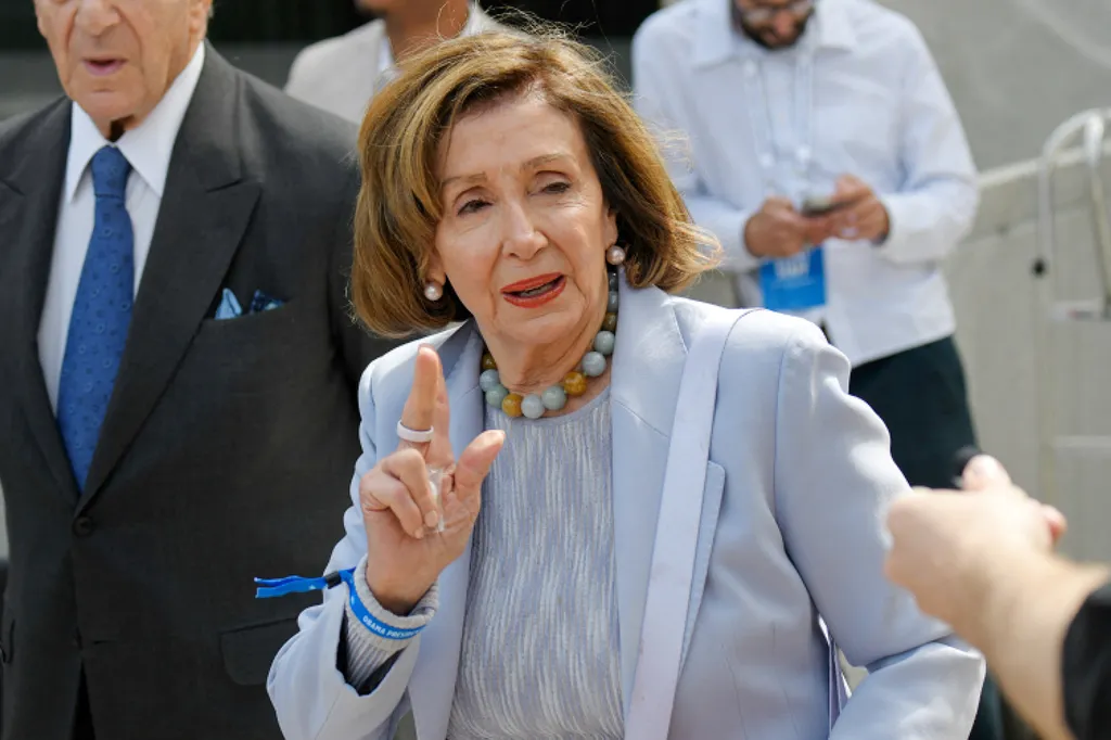 Nancy Pelosi speaking at an event, pointing with her right hand.