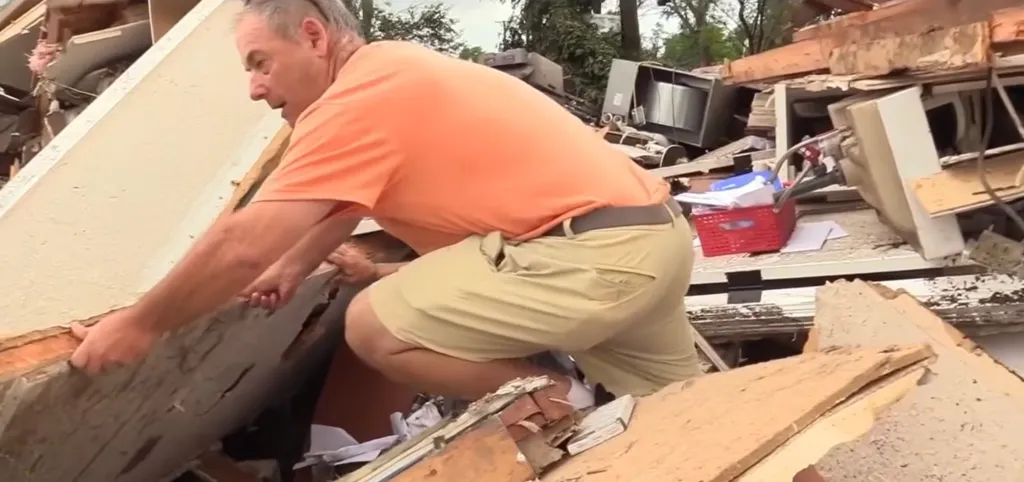 Man sorting through debris after a natural disaster.