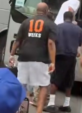 Man in a black t-shirt with "10 WEEKS" in orange and white text.