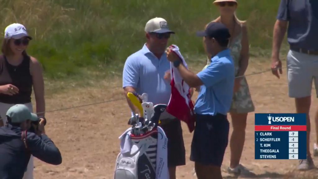 Miles Russell's dad, Joe, given the caddie bib ahead of the 18th hole at the U.S. Open on Sunday.