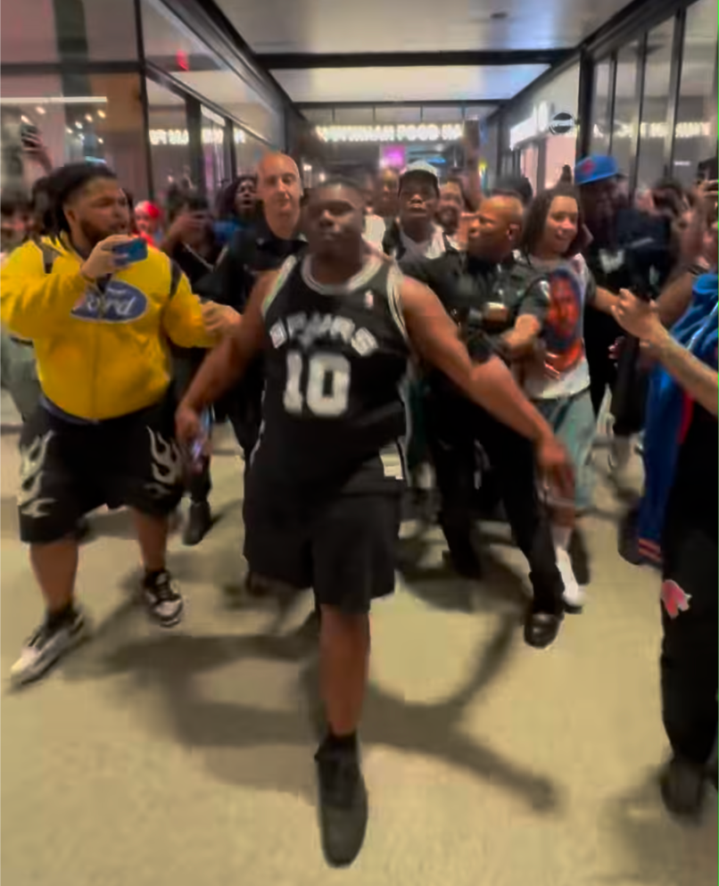 Cops escort the Spurs fan away on June 13, 2026.