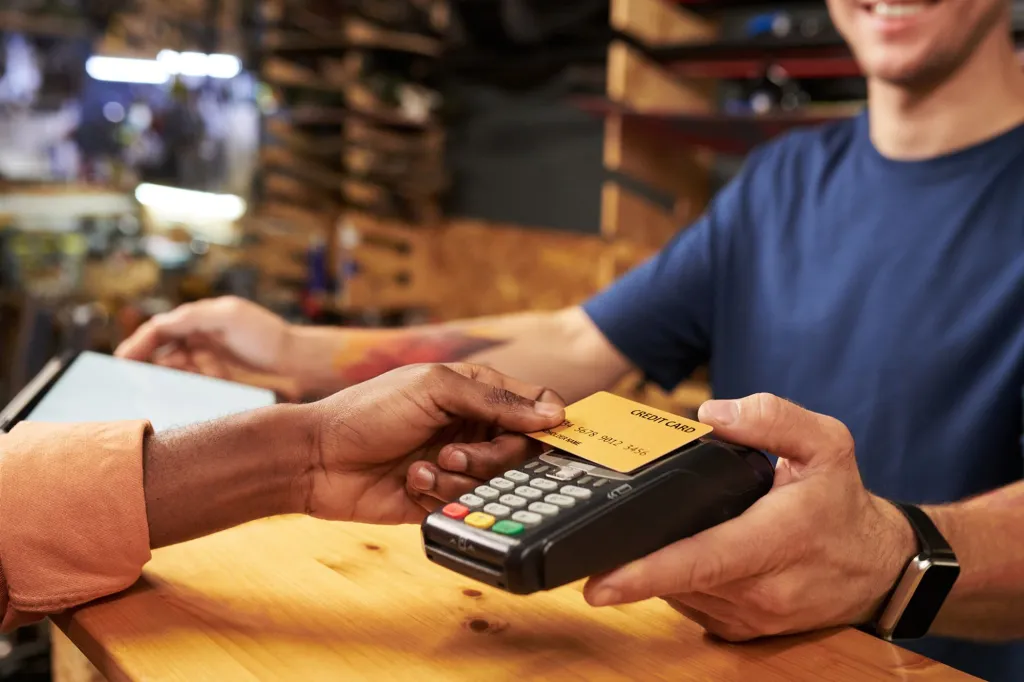 A person using a credit card at a counter.