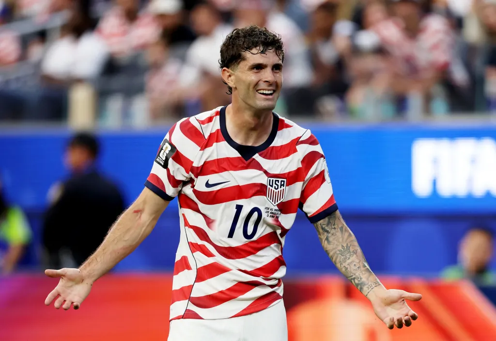 Christian Pulisic in a USA soccer jersey with number 10, smiling during a match.