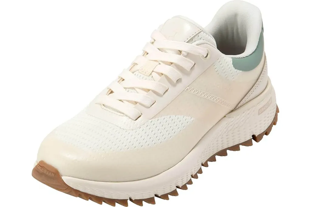 A light beige and white sneaker with a brown, jagged sole.
