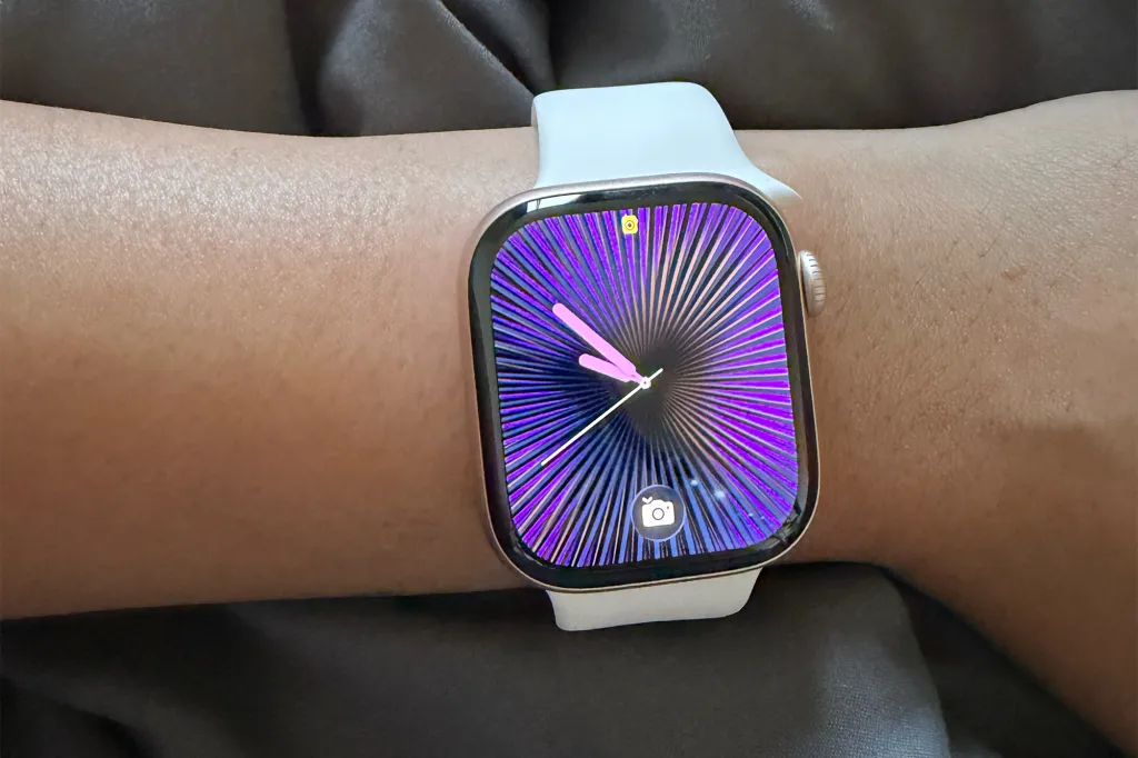 An Apple Watch Series 11 on a wrist with a purple radial face and white band.