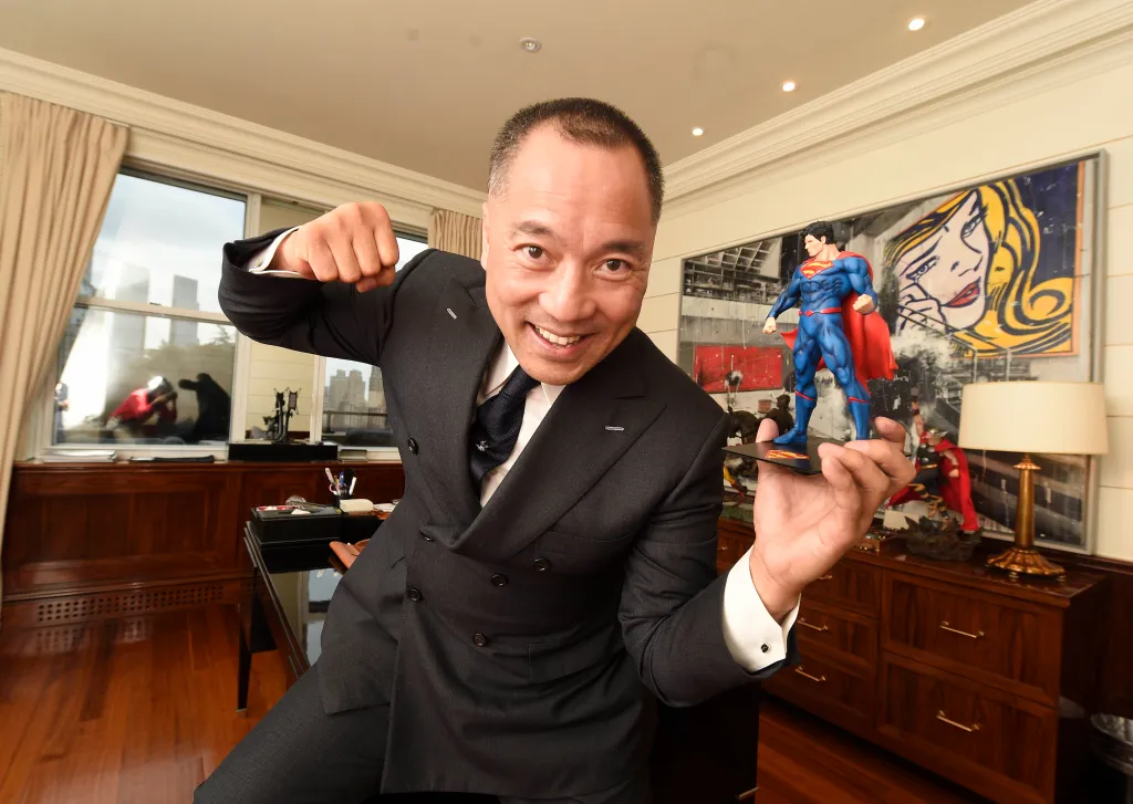 Miles Kwok, a Chinese businessman and activist, posing with a Superman figurine.