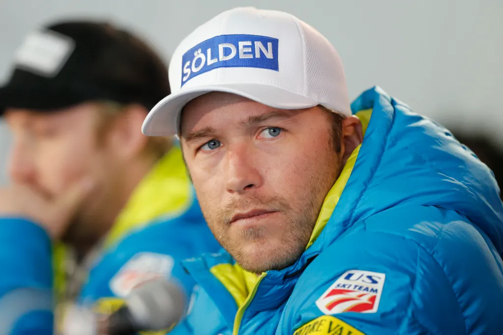 Bode Miller wearing a white baseball cap with "Sölden" in blue lettering and a blue ski jacket with a "US SKI TEAM" patch.