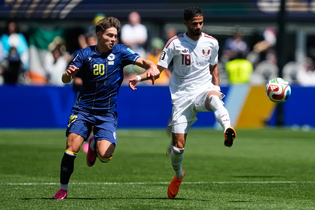 Esmir Bajraktarevic of Bosnia and Sultan Albrake of Qatar challenge for the ball during a World Cup Group B soccer match.