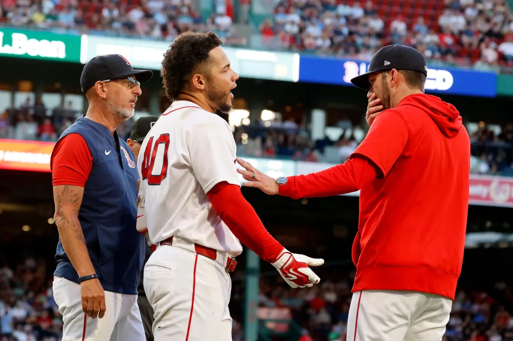 Boston Red Sox interim manager Chad Tracy holds back Willson Contreras after Contreras was ejected for contesting a call.