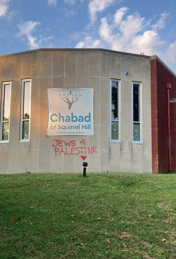 The exterior of the Chabad of Squirrel Hill building with red spray paint graffiti reading "JEWS 4 PALESTINE" and a downward pointing triangle.