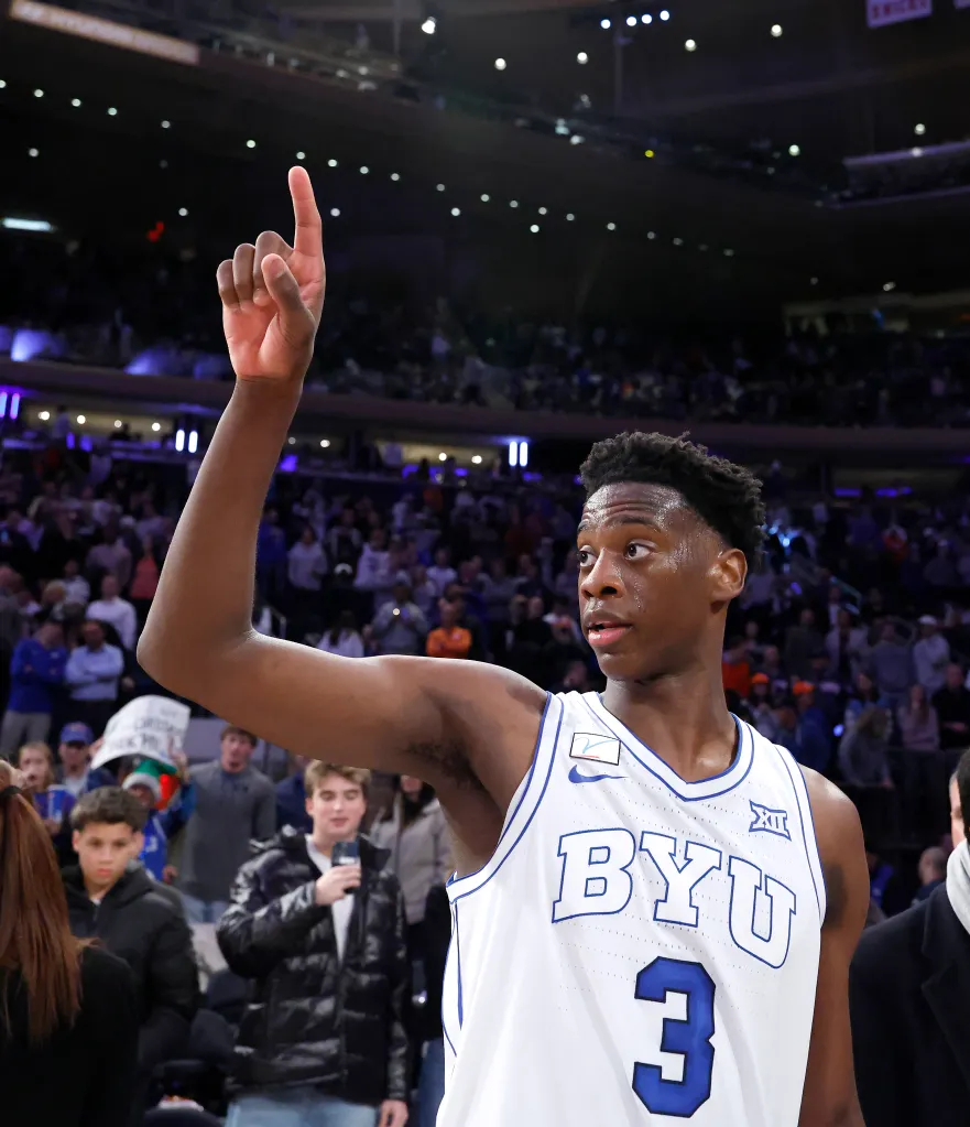 BYU Cougars forward AJ Dybantsa celebrating by raising his right arm and pointing his index finger up.