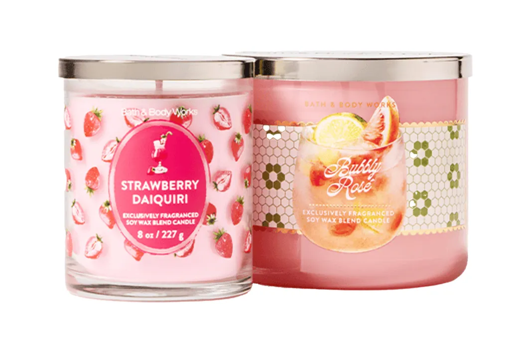 Two Bath & Body Works candles, one "Strawberry Daiquiri" and one "Bubbly Rose."