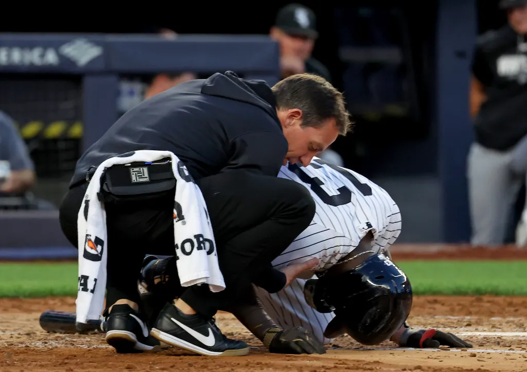 Yankees second baseman Jazz Chisholm Jr. being checked on by a trainer after fouling the ball off his groin.