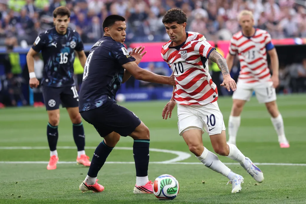 USA's Christian Pulisic battles for the ball with Paraguay's Diego Gomez during the FIFA World Cup 2026 Group D match.