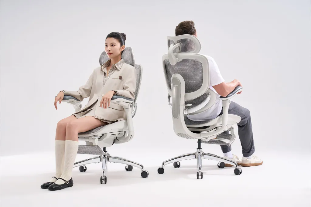 Woman and man sitting in ergonomic office chairs.