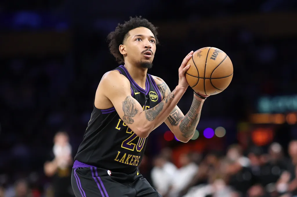 Los Angeles Lakers player Jalen Hood-Schifino holding a basketball in preparation to shoot.