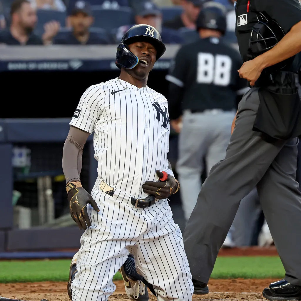 New York Yankees second baseman Jazz Chisholm Jr. on his knees in pain after fouling a ball off his groin.