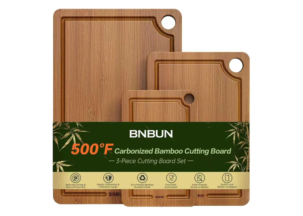 A set of three carbonized bamboo cutting boards with grooves and circular holes, in varying sizes.