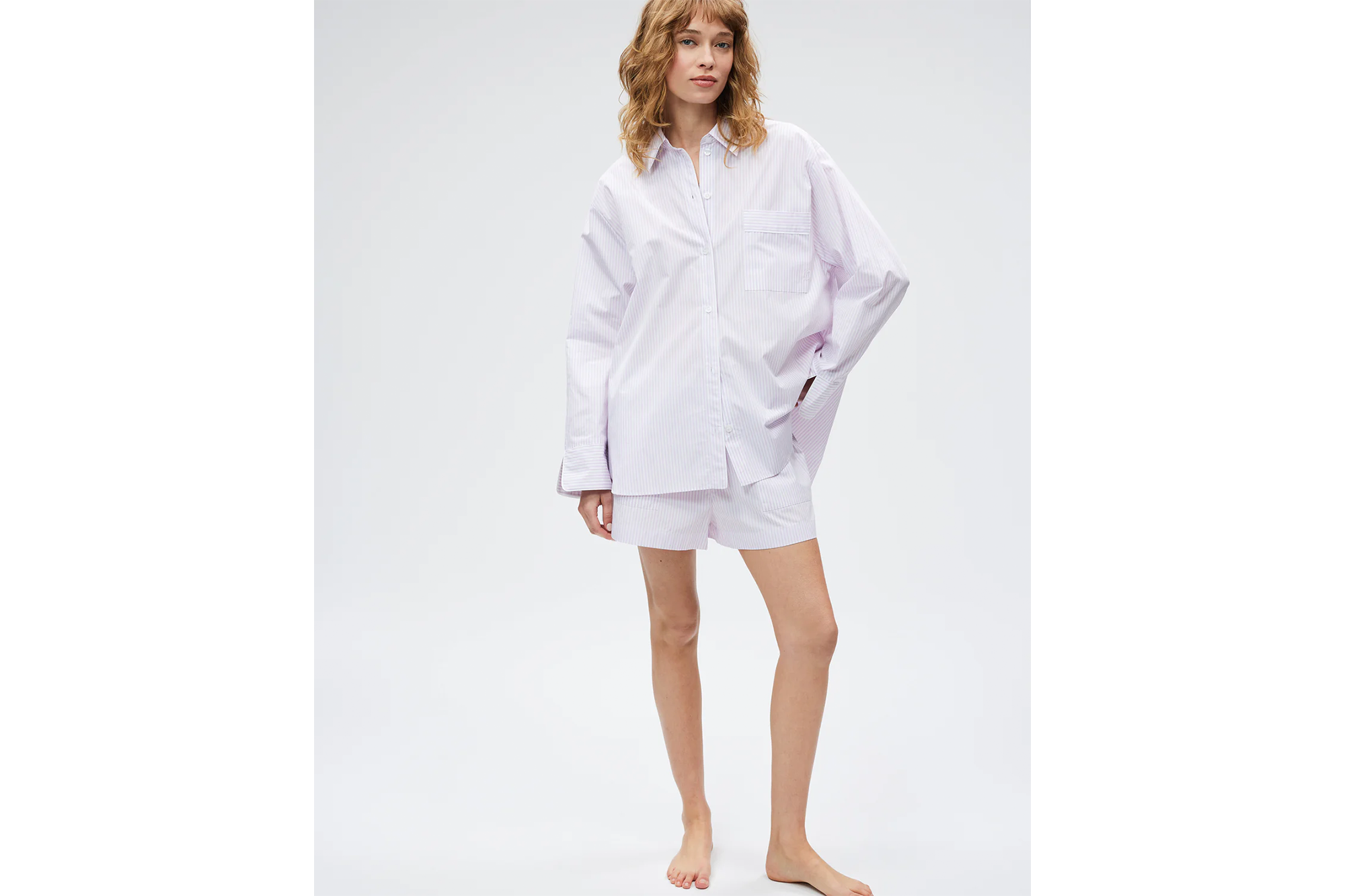 Woman wearing a purple striped button-up shirt and matching shorts.
