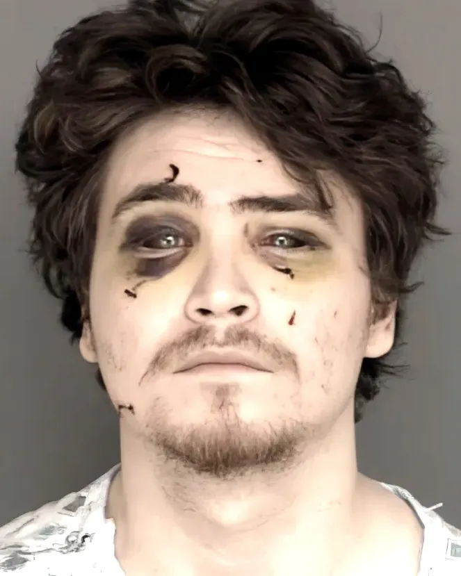 Mugshot of Devin Wolfgang Vanderhoef with bruised eyes and small cuts on his face.