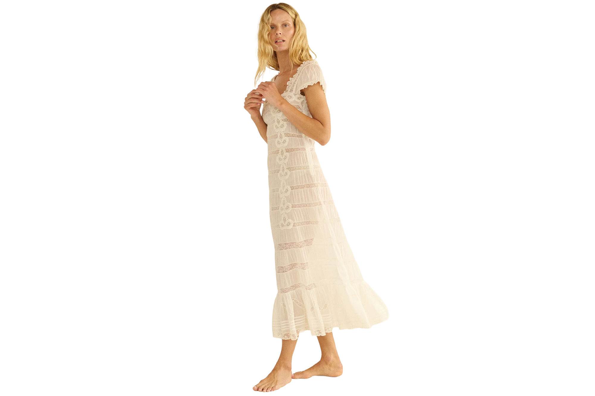 A blonde woman in a white lace dress with ruffle sleeves and hem.