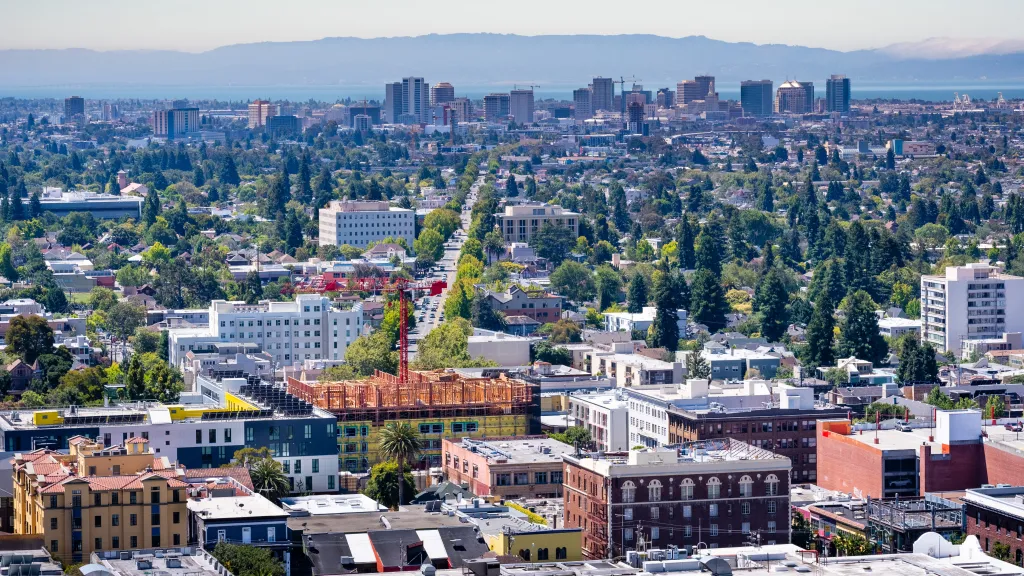 Aerial view of Berkeley and North Oakland with downtown Oakland and San Francisco Bay in the background.