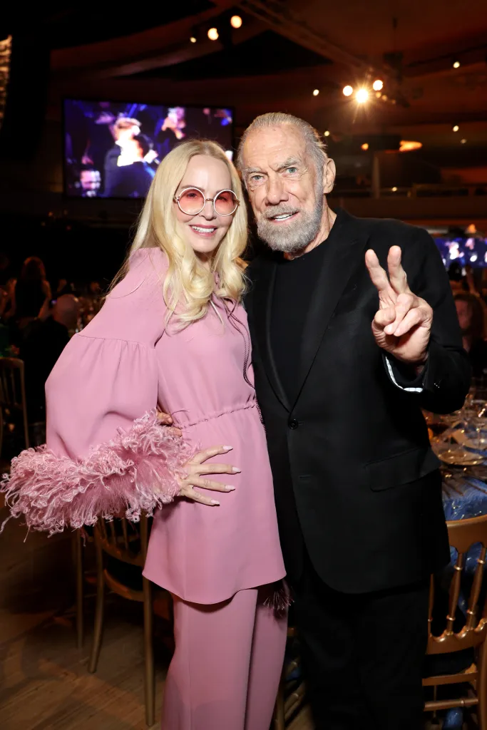 Eloise Broady DeJoria in a pink outfit and John Paul DeJoria in a black suit pose at the 7th Annual Jam for Janie GRAMMY Awards Viewing Party.