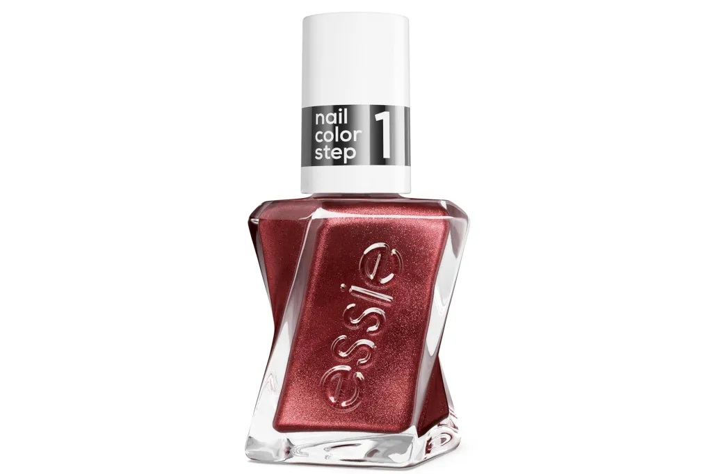 A bottle of Essie Gel Couture nail polish in a shimmery red color with the words "nail color step 1" on the cap.