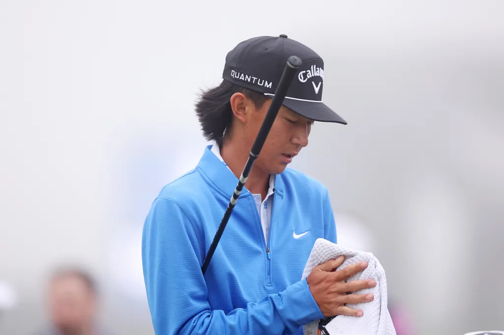 Ethan Fang cleaning his golf club during the first round of the U.S. Open golf tournament.