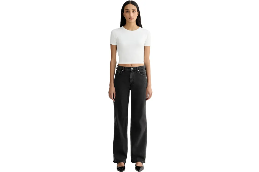 A model wearing a white ribbed short-sleeve top and black wide-leg jeans.