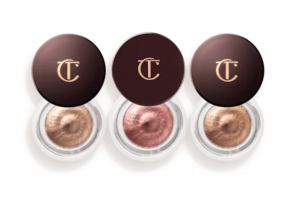 Three open pots of Charlotte Tilbury Eyes to Mesmerise cream eyeshadow in shades Champagne, Rose Gold, and Amber Gold.