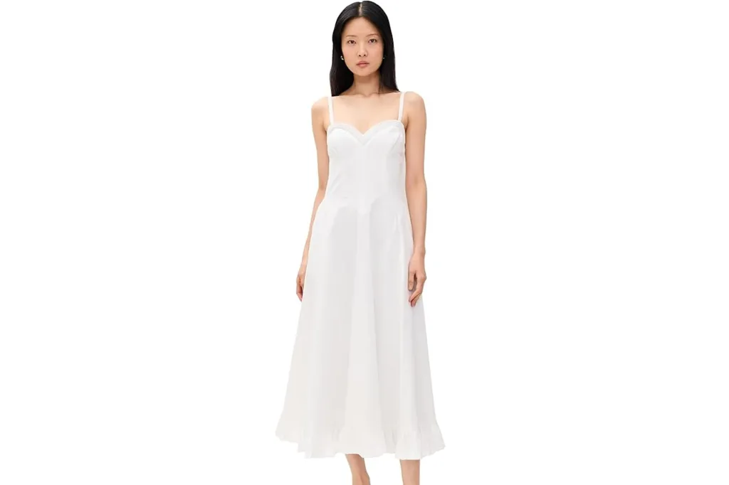 Young woman wearing a white spaghetti strap midi dress with a ruffled hem.