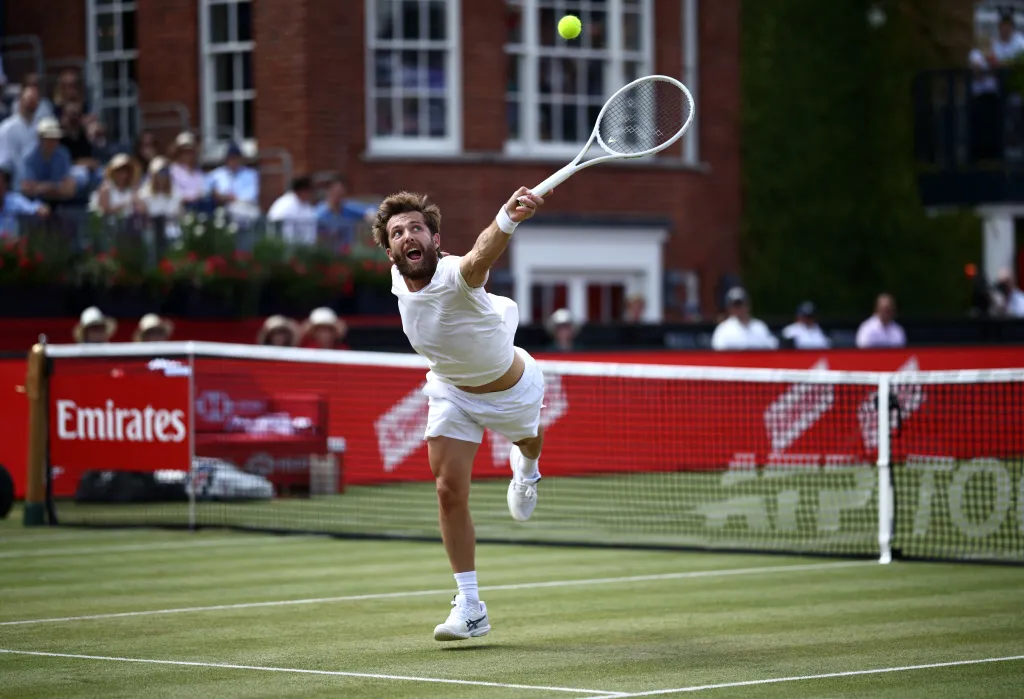 Tennis player Corentin Moutet serves the ball during a match.