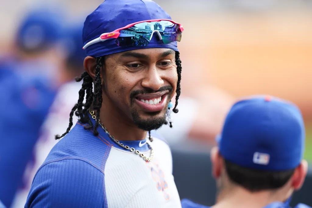New York Mets shortstop Francisco Lindor smiling from the dugout during a baseball game.